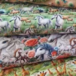 Katoenstoffen met Paarden Giraffes & Tractor Varkentjes print-van-galopperende-paarden-moeder-giraffe-met-kleintje-en-varkentje-op-een-tractor