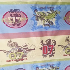 Harry Potter katoenstof kleurrijke print met Harry op bezem en Gryffindor logo’s Online stof bestellen bij makomastoffen Almere