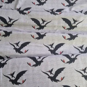 Tricot stof met draken zwarte draak met rode zadel op lichtgrijze achtergrond Makomastoffen Nederland